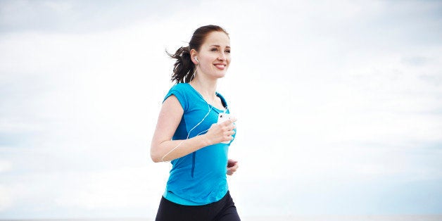 Female runner with mps on coastal promenade