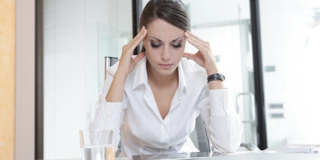 Overworking business woman suffering from headache