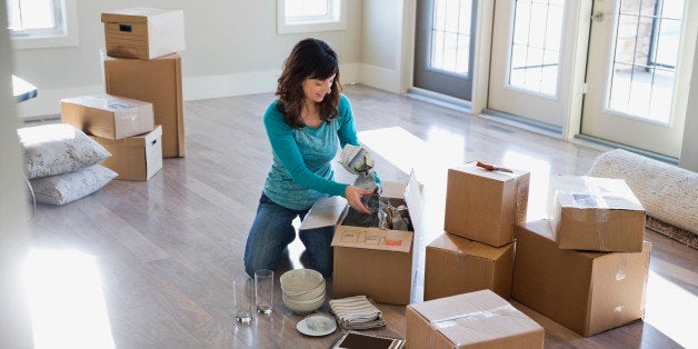 Woman unpacking cardboard boxes in new home