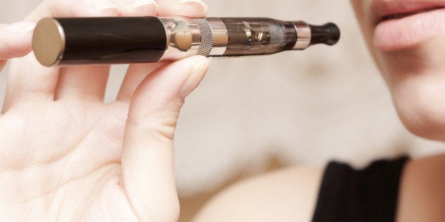 Close up of a woman inhaling from an electronic cigarette