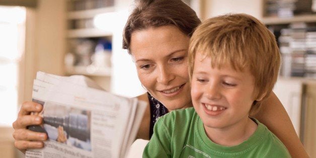 Mother and son reading newspaper together