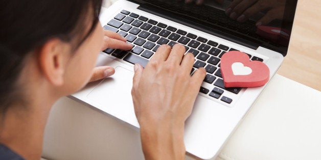 Young Happy Woman Showing Heart Shape While Using Laptop On Couch