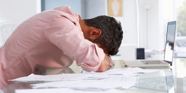 Stressed Man Working At Laptop In Home Office