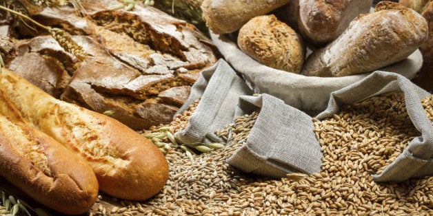 Various kinds of whole wheat bread on old wooden table.