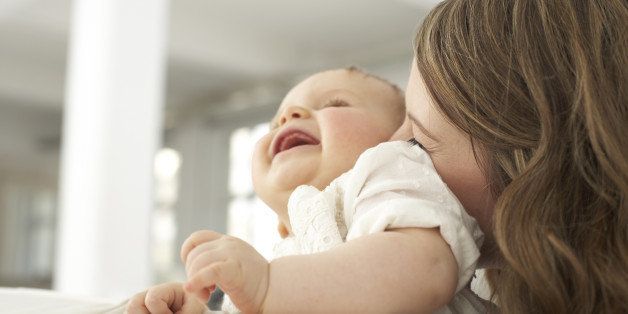 Mother kissing her laughing baby girl