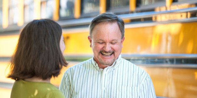 Charming smile on laughing man as two parents talk at the bus stop.