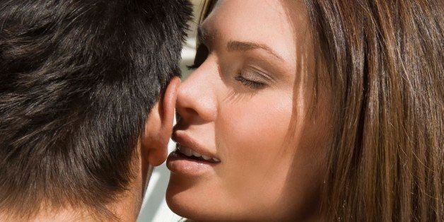 Woman whispering to man