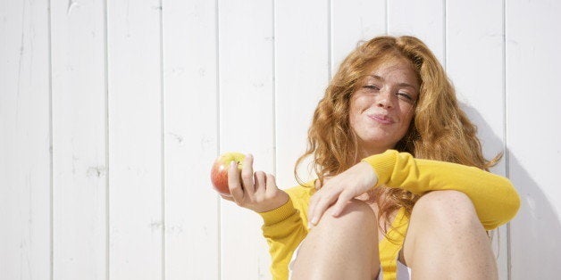 Young woman holding apple, portrait