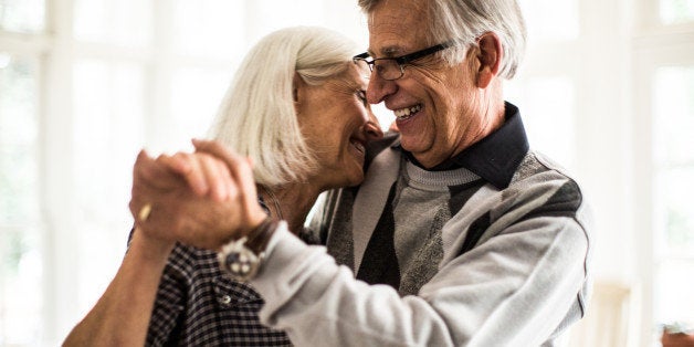 Senior couple dancing in living room