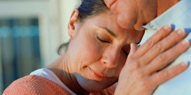 Middle-aged couple hugging with eyes closed