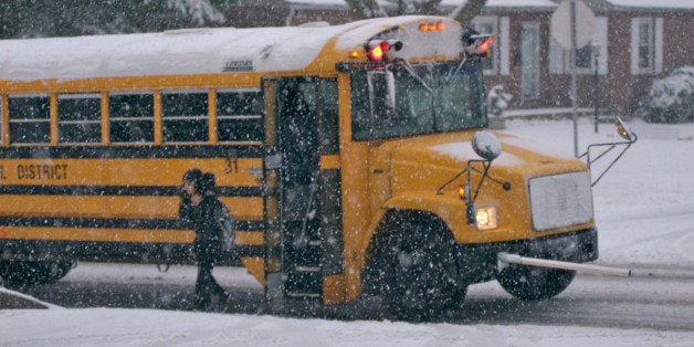 Girl (10-11) disembarking school bus in snow