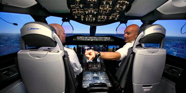 Pilot Gregg Pointon, right, shows off the cockpit of a Boeing 787 full-flight simulator during a media tour of the company's