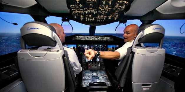 Pilot Gregg Pointon, right, shows off the cockpit of a Boeing 787 full-flight simulator during a media tour of the company's training tools for their newest jet Thursday, Aug. 26, 2010, in Renton, Wash. Boeing has previously demonstrated other 787 training tools, including its interactive maintenance classroom, cabin-safety trainer and flight training device simulator. The company has provisional approval from the FAA on the Thales-built 787 flight-training hydraulic-electric hybrid simulators , allowing them to begin training customer pilots, the company announced Thursday. The FAA will remove the provisional designation once it certifies the airplane. (AP Photo/Elaine Thompson)