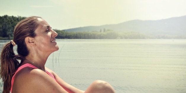 woman meditating on the bank of a lake