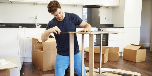 Man Putting Together Self Assembly Furniture In New Home On Both Knees