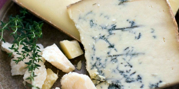 This March 2, 2011 photo shows cave-aged Gruyere, background, Jasper Hill Farm Bayley Hazen Blue, middle, and parmigiano-reggino in Concord, N.H. Some artisanal cheesemakers swear by "raw" milk _ straight-from-the-udder and unpasteurized _ saying it gives their products personality and depth of character by retaining the good bacteria that otherwise are killed during pasteurization. (AP Photo/Matthew Mead)
