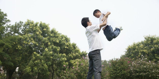 Chinese father and son playing in park