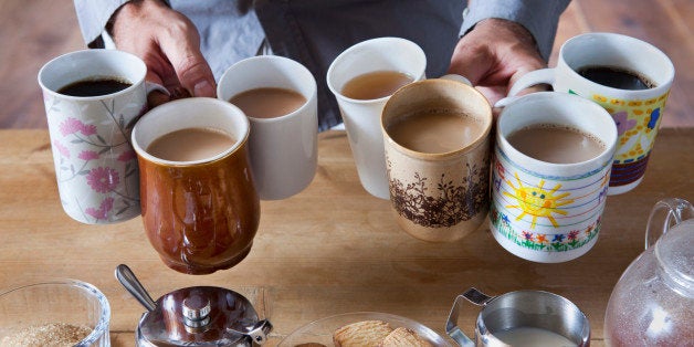 Man holding many tea and coffee cups