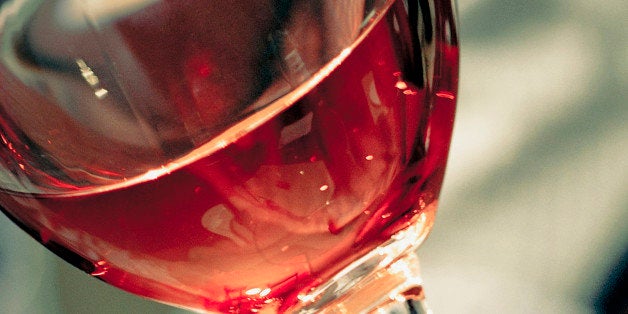 Close-up of a man's hand holding a glass of red wine