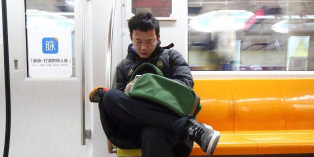 A commuter uses a smartphone as he travels on a subway train in Beijing, China, on Friday, March 6, 2015. China set the lowest economic growth target in more than 15 years and flagged increasing headwinds as leaders tackle the side effects of a generation-long expansion that spurred corruption, fueled debt and hurt the environment. Photographer: Tomohiro Ohsumi/Bloomberg via Getty Images