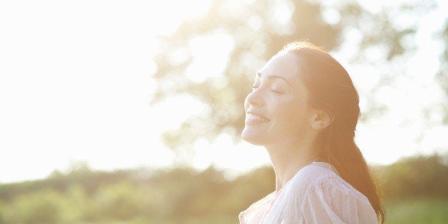 Profile of woman with eyes closed in countryside.