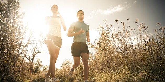 Caucasian couple running together on path