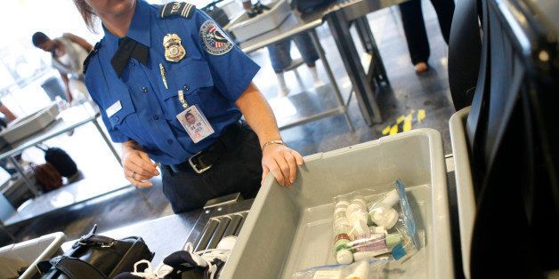 FILE - In this June 27, 2008 file photo, shoes and small liquid containers are placed in bins to be screened by TSA Supervisor Jennifer Haslip at the x-ray machine at Washington's Ronald Reagan National Airport. The TSA has demonstrated a knack for ignoring the basics of customer relations, while struggling with what experts say is an all but impossible task. It must stand as the last line against unknown terror, yet somehow do so without treating everyone from frequent business travelers to the family heading home to visit grandma as a potential terrorist. (AP Photo/Pablo Martinez Monsivais, File)