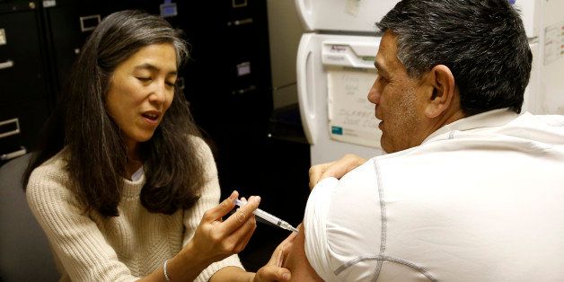 Dr. Julie Morita, Director of Immunizations at the Chicago Dept. of Public Health, gives Gary Chavarria a flu shot at a North Side clinic Friday, Jan. 11, 2013, in Chicago. Illinois is among the 24 states across the nation hardest hit by the flu, but vaccine is still available in most locations, health officials said Friday as they urged people to get their shots. (AP Photo/Charles Rex Arbogast)