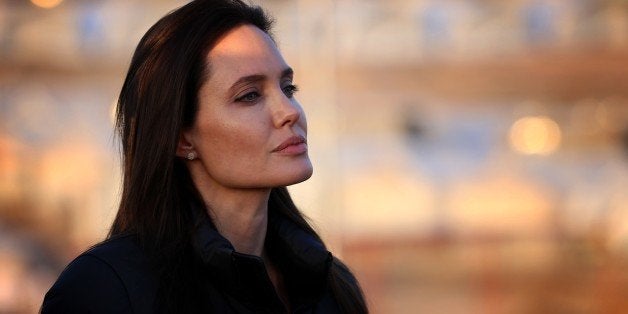 US actress and UNHCR ambassador Angelina Jolie stands during a visit to a camp for displaced Iraqis in Khanke, a few kilometres (miles) from the Turkish border in Iraq's Dohuk province, on January 25, 2015. Run by authorities from the three-province autonomous Kurdish region of north Iraq with the help of the United Nations refugee agency, the UNHCR, Khanke aims to house 18,000 people, said the agency's Liena Veide. AFP PHOTO/SAFIN HAMED (Photo credit should read SAFIN HAMED/AFP/Getty Images)