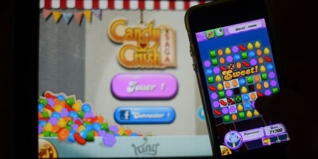 (FILES) In this file picture taken on January 25, 2014 a man plays at Candy Crush Saga on his Iphone in Rome. Candy Crush is one of the top online games developped by King.com. With three young children and a full-time job, Emma Martini has little time for computer games. But every night she sits quietly at the end of her son's bed to reassure him while he falls asleep -- and plays Candy Crush. AFP PHOTO / GABRIEL BOUYS (Photo credit should read GABRIEL BOUYS/AFP/Getty Images)