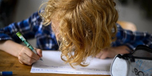 Swiss boy Leon, 9, does his homework on June 20, 2013 in his home in Moudon, western Switzerland. AFP PHOTO / FABRICE COFFRINI RESTRICTED TO EDITORIAL USE (Photo credit should read FABRICE COFFRINI/AFP/Getty Images)