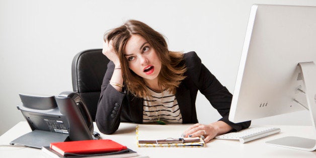 Studio shot of young woman working in office being under emotional stress