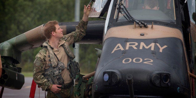 In this April 14, 2015, photo provided by the Australian Defence on Monday, April 20, 2015, Britain's Prince Harry opens the door of an Armed Reconnaissance Helicopter (ARH) Tiger from 1st Aviation Regiment prior to a familiarization flight at Robertson Barracks in Darwin, Australia. Capt. Wales was briefed on Australian Army's North-West Mobile Force's operations and received his orders before he headed out on a patrol. (Cpl. Oliver Carter/Australian Defence via AP)