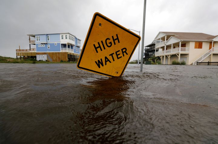 Flood waters lap at a high water warning sign that was partially pushed over by Hurricane Florence on Oak Island, North Carolina, September 15, 2018. (REUTERS/Jonathan Drake)