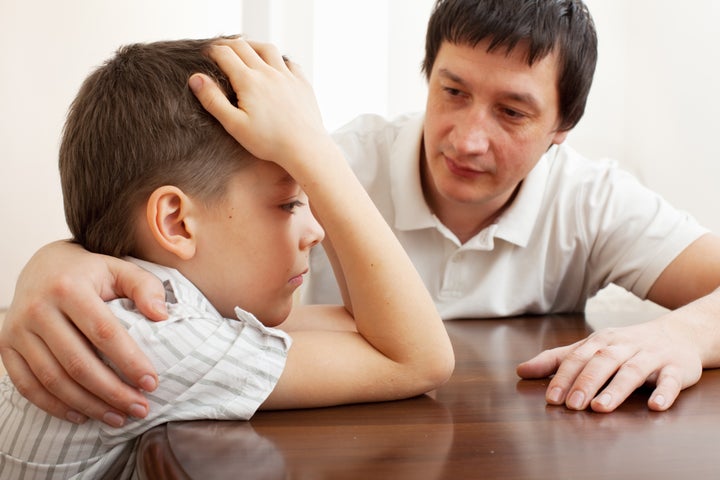 Father comforts a sad child. Problems in the family