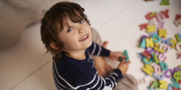 Portrait of an adorable little boy playing with colorful toy letters