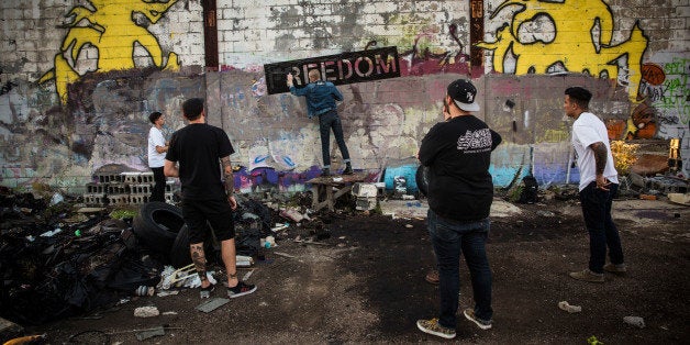 DETROIT, MI - SEPTEMBER 04: Members of the band 'Freedom' spray paint their name on a wall at the abandoned Packard Automotive Plant on September 4, 2013 in Detroit, Michigan. The Packard Plant was a 3.5 million square foot car manufacturing plant built completed in 1911. Major operations ceased in 1958, though the plant was used in a limited capacity until the 1990s, with outer buildings used through the mid 2000s. Since then the buildings have fallen into disrepair - they are now used mostly for graffitti artists and scavengers. Detroit has an astonishing 78,000 abandoned buildings across its 142 square miles. Last month the city declared bankruptcy, the largest municipality to ever do so in the United States. (Photo by Andrew Burton/Getty Images)