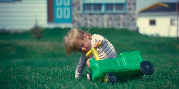 Young boy falling off a ride-on plastic toy