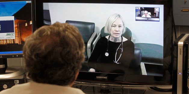 In this Thursday, Dec. 20, 2012 photo, Dr. Terry Rabinowitz, back to camera, talks with nurse Leslie Orelup at Helen Porter Nursing Home on in Burlington, Vt. New health insurance regulations in Vermont are giving a boost to telemedicine, the system that enables health care providers to offer consult with patients without being in the same room. Telemedicine isnￃﾢￂﾀￂﾙt new, but the new regulations make it easier for physicians to be reimbursed for services performed by two-way video hookups. Fletcher Allen Telemedicine director Dr. Terry Rabinowitz says popular specialties are psychiatry and dermatology. (AP Photo/Toby Talbot)