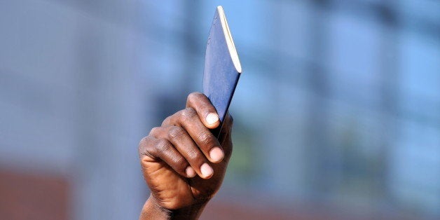 A Haitian holds up his passport at the passport and immigration centre in Port-au-Prince on January 22, 2010. Hundreds of Haitians are queuing every day to try and either get a new passport after losing theirs in the devastating January 12 earthquake or to be reissued passports with valid visas in order to leave the country. AFP PHOTO / LUIS ACOSTA (Photo credit should read LUIS ACOSTA/AFP/Getty Images)