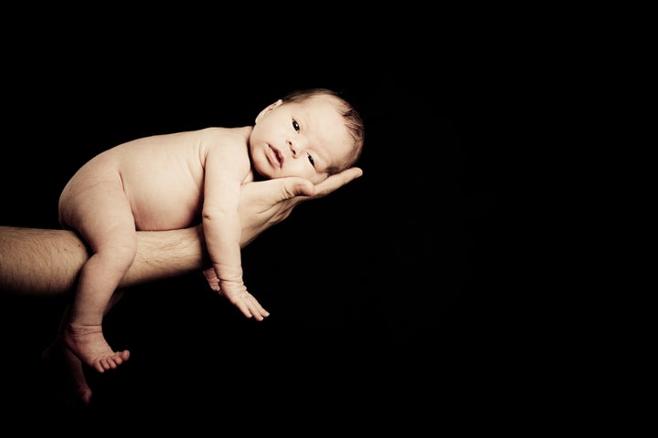 newborn baby lying on his...