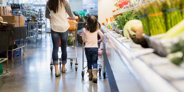 Mother and daughter pushing shopping carts in store