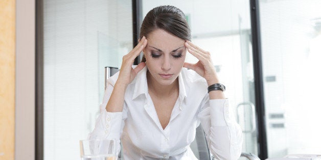 Overworking business woman suffering from headache