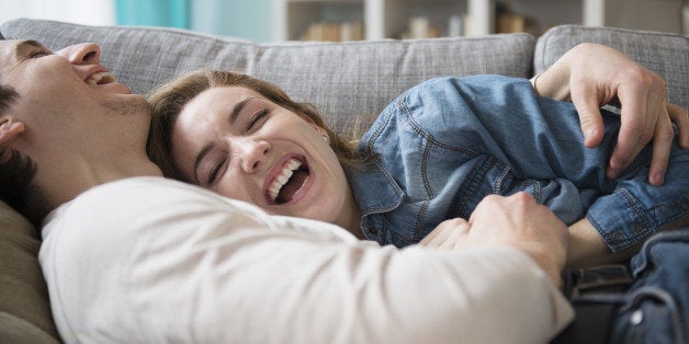 Couple laughing together on couch