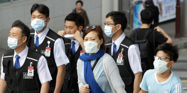 SEOUL, SOUTH KOREA - JUNE 02: People wear masks as a precaution against the MERS virus on June 2, 2015 in Seoul, South Korea. The Ministry of Health and Welfare of South Korea confirmed two deaths from Middle East Respiratory Syndrome (MERS) on June 2, 2015. It reported six new cases of MERS, raising the number of confirmed local patients to 25. The first case was confirmed on May 20. (Photo by Chung Sung-Jun/Getty Images)