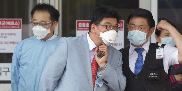 SEOUL, SOUTH KOREA - JUNE 02: Hospital workers wearing masks to protect them against the MERS virus at a quarantine tent for people who could be infected with the MERS virus at Seoul National University Hospital on June 2, 2015 in Seoul, South Korea. The Ministry of Health and Welfare of South Korea confirmed two deaths from Middle East Respiratory Syndrome (MERS) on June 2, 2015. It reported six new cases of MERS, raising the number of confirmed local patients to 25. The first case was confirmed on May 20. (Photo by Chung Sung-Jun/Getty Images)