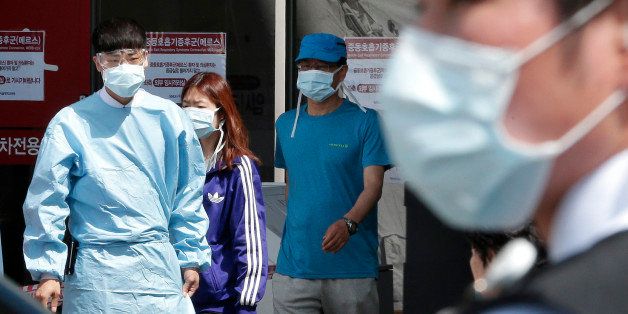 Hospital workers and visitors wearing masks pass by a precaution against the MERS, Middle East Respiratory Syndrome, virus at a quarantine tent for people who could be infected with the MERS virus at Seoul National University Hospital in Seoul, South Korea, Wednesday, June 3, 2015. South Korea on Tuesday confirmed the country's first two deaths from MERS as it fights to contain the spread of a virus that has killed hundreds of people in the Middle East.(AP Photo/Ahn Young-joon)