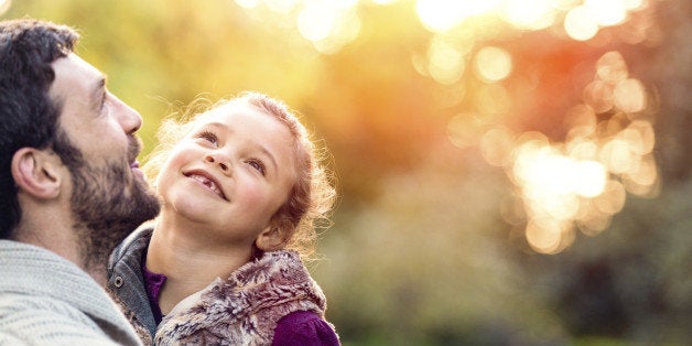 Father and daughter enjoying outdoors on a sunny autumn day.