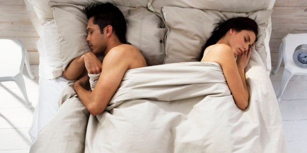 Couple Sleeping on Opposite Sides of Bed