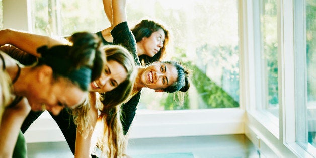 Smiling woman laughing with friends during yoga class in studio